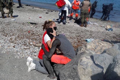 Una voluntaria de la Cruz Roja Española abraza a un inmigrante senegalés recién llegado a Ceuta a nado.