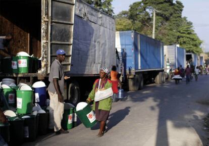 Una haitiana recibe un lote de utensilios básicos distribuidos por una organización humanitaria ayer en Puerto Príncipe