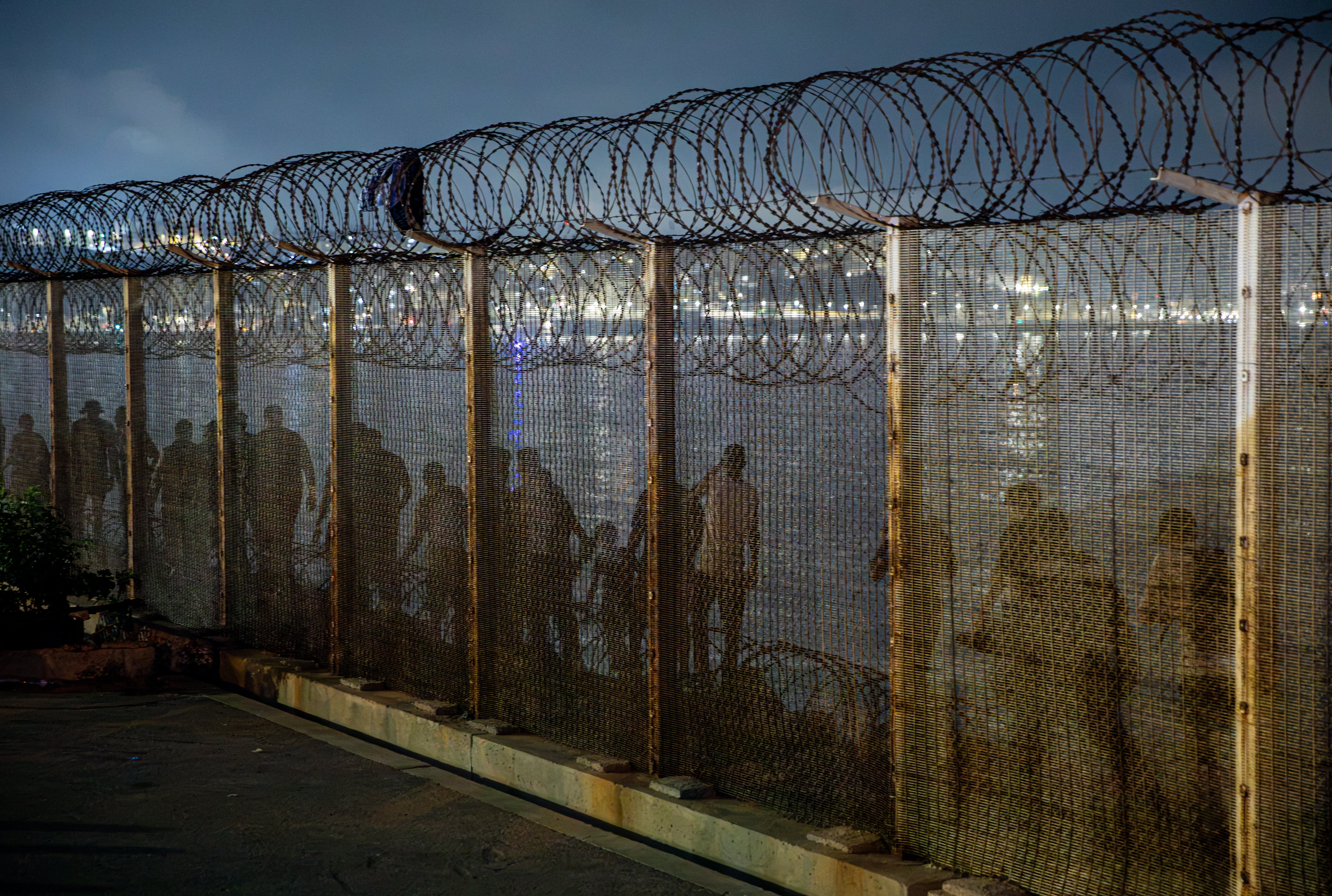 Migrantes irregulares marroquíes avanzan en dirección a Ceuta por la frontera de Castillejos en la madrugada del viernes.