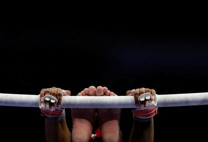 La gimnasta Simone Biles se agarra a una de las barras asimétricas durante una jornada de entrenamiento antes de las pruebas del equipo olímpico de gimnasia de Estados Unidos en San Luis.