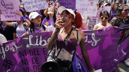 Una mujer grita arengas en con un megáfono, este viernes 8 de marzo.