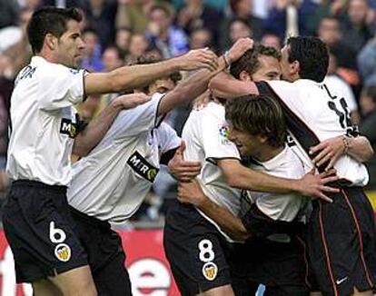 Los jugadores del Valencia abrazan a Baraja después de marcar éste el primer gol del partido.