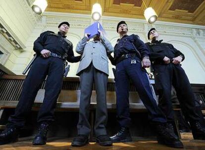 Josef Fritzl se esconde tras una carpeta azul a su entrada ayer en la sala de juicios, custodiado por la policía.
