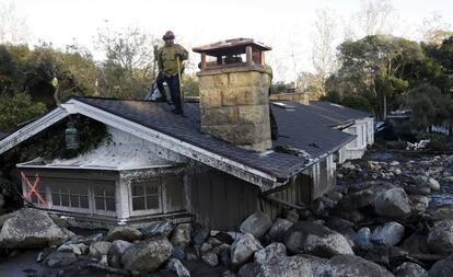 Un bombero observa desde el tejado de una casa afectada por un alud de rocas y barro en Montecito, California, el 10 de enero de 2018. 