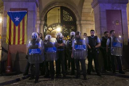 Miembros de los Mossos permanecen frente a la puerta del Parlament tras el intento de asalto de manifestantes independentistas.