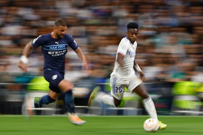 El delantero Real Madrid Vinicius Junior (d) escapa de Kyle Walker, del Manchester City, durante el partido de semifinales de la Liga de Campeones. 