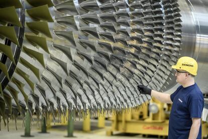 Un trabajador junto a una turbina en la planta de Siemens en Berl&iacute;n.