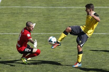 Carriço, del Sevilla, intenta superar al meta Rubén Martínez.