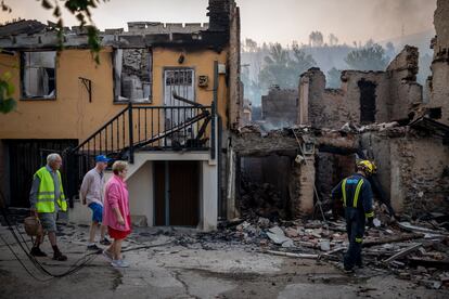 Vecinos de la localidad ourensana de A Veiga da Cascallá (Rubiá) pasaban el martes ante varias casas arrasadas por las llamas.