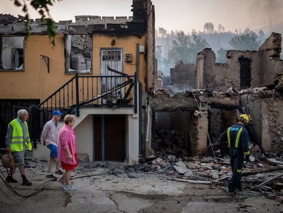 Vecinos de la localidad ourensana de A Veiga da Cascallá (Rubiá) pasaban el martes ante varias casas arrasadas por las llamas.