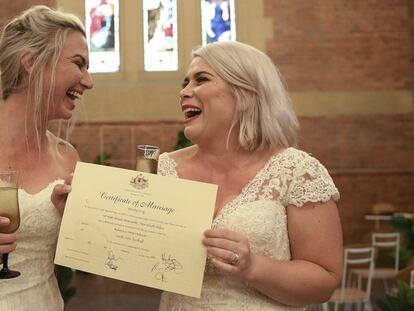 Sarah Turnbull (izquierda) y Rebecca Hickson (derecha) con su certificado de matrimonio después de casarse el lunes en Newcastle (Australia).