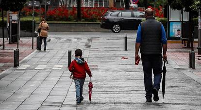 Un hombre pasea junto a un niño en Sevilla, este lunes.