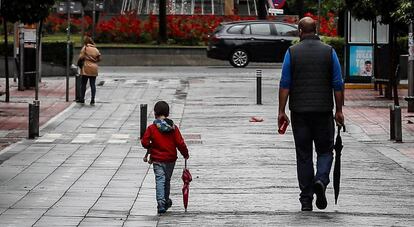 Un hombre pasea junto a un niño en Sevilla, este lunes. 