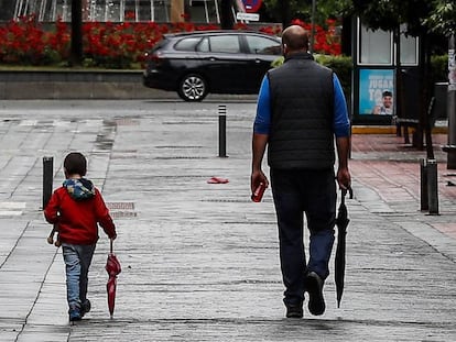 Un hombre pasea junto a un niño en Sevilla, este lunes. 