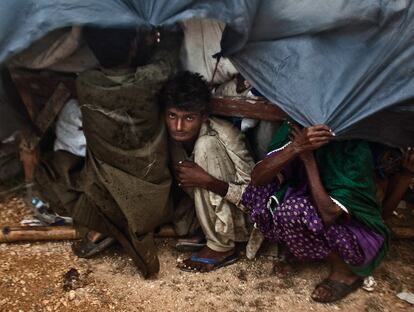 Las condiciones meteorológicas y la escasez de ayudas anclan a los desplazados en condiciones inhumanas. Una familia se cobija de los estragos de la lluvia en un improvisado 'campamento' a las afueras de Thatta.