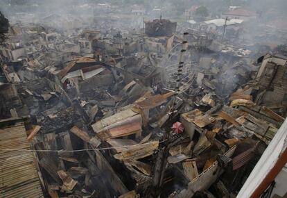 Residentes rescatan artículos personales tras el incendio que destruyó un vecindario en Las Pinas, al sur de Manila, Filipinas. Unas 800 casas fueron arrasadas por el fuego y más de 1.000 familias se han quedado sin techo.