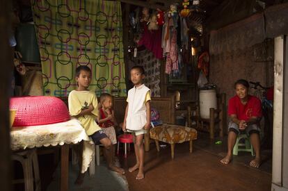 Una familia en el interior de una vivienda en Anibong, una de las zonas mas afectadas por el tifón.
