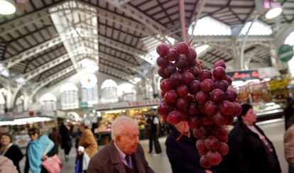 Un racimo de uvas cuelga en un puesto del Mercado Central de Valencia.