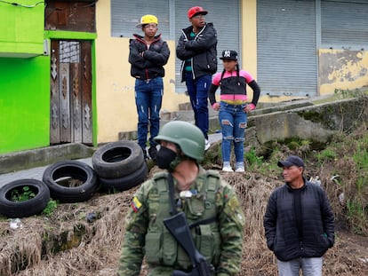 Ciudadanos observan a soldados ecuatorianos patrullar un barrio de Quito, el 12 de enero.