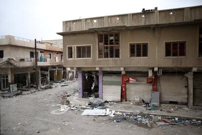 Vista de una calle desierta con viviendas dañadas por la guerra.