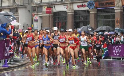 Las corredoras continúan su carrera mientras la lluvia cae más fuerte.