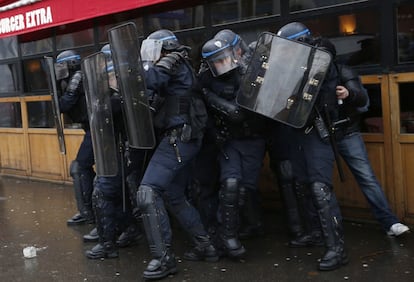 Las organizaciones convocantes de la huelga han organizado más de 200 manifestaciones por todo el país. En la imagen, un grupo de policías franceses se protege durante un enfrentamiento en París, el 31 de marzo de 2016.