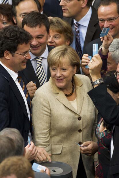 Angela Merkel, rodeada de sus diputados en la votación para ampliar el rescate europeo.