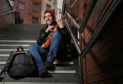 Aitor Toledo, músico callejero, junto a su guitarra en las escaleras de la estación de Antón Martín, en Madrid.
