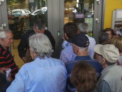 Pensionistas hacen cola para retirar dinero a la entrada de una sucursal bancaria en Sal&oacute;nica, Grecia.