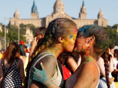Dos jóvenes se dan un beso en la manifestación del Orgullo en Barcelona.