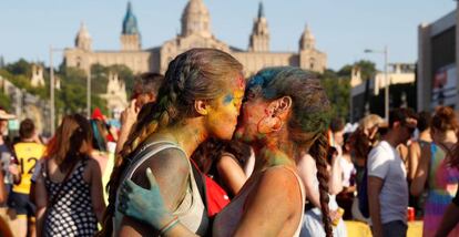 Dos jóvenes se dan un beso en la manifestación del Orgullo en Barcelona.