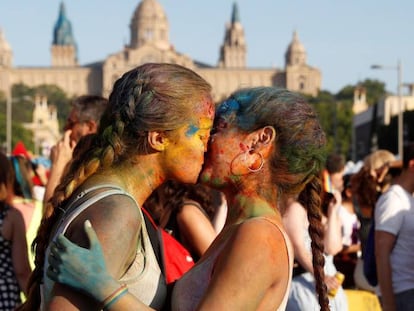 Dos jóvenes se dan un beso en la manifestación del Orgullo en Barcelona.