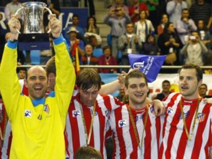 Hombrados levanta la copa entre jugadores del Atl&eacute;tico.