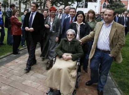 La hija de Maite Torrano ayuda a su nuera en silla de ruedas, en presencia de dirigentes socialistas.