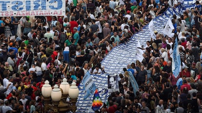 Miles de personas marchan hacia Plaza de Mayo con una gran pancarta con rostros de desaparecidos durante la última dictadura argentina.