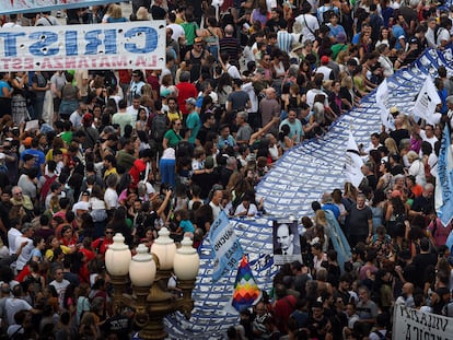 Miles de personas marchan hacia Plaza de Mayo con una gran pancarta con rostros de desaparecidos durante la última dictadura argentina.