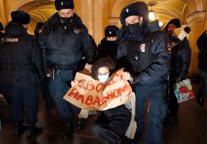 Dos policías detienen a una mujer que lleva una pancarta con el lema "libertad para Navalni", este lunes en San Petersburgo. 