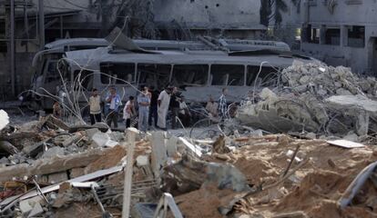 Un grupo de palestinos observan los restos de un edificio tras el bombardeo de Israel a Gaza, el pasado lunes.