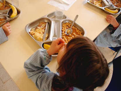 Unos niños comen en el comedor escolar.