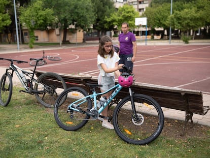 Elena López aparca su bici ante la mirada de su padre Javier López.