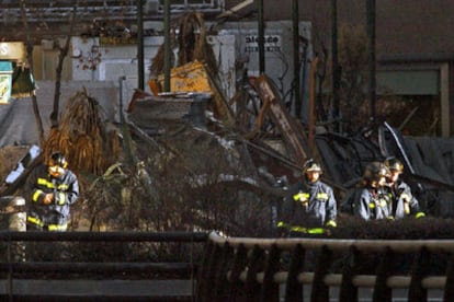 Agentes de bomberos en el momento de acceder a los bajos del inmueble siniestrado.