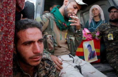 Combatientes de las Fuerzas Democráticas Sirias se sientan junto al ataúd de un compañero asesinado por el Estado Islámico en Raqqa (Siria).