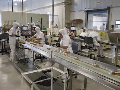 Trabajadores empaquetan chocolates en la línea de producción de la Compañía Nacional de Chocolate de Grupo Nutresa, en Medellín (Colombia) en junio de 2017.