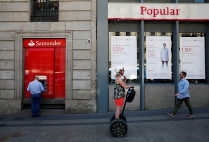 Un hombre saca dinero de un cajero automático de Santander, ahora dueño de Popular