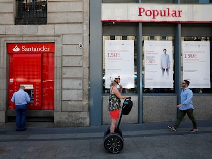 Un hombre saca dinero de un cajero automático de Santander, ahora dueño de Popular