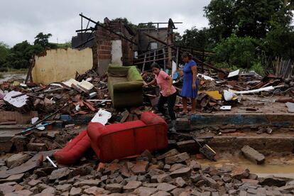 Juliana Reis y Fabiana Batista de Oliveira, caminan sobre los escombros de la casa de Fabiana que fue destruida por las inundaciones en Itambe, Estado de Bahía.