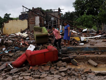 Juliana Reis y Fabiana Batista de Oliveira, caminan sobre los escombros de la casa de Fabiana que fue destruida por las inundaciones en Itambe, Estado de Bahía.