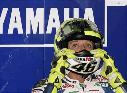 Rossi ajusta su casco en el 'pit'