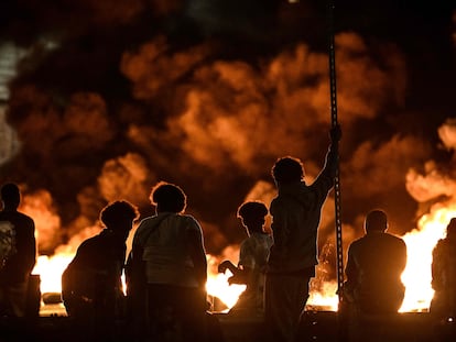 Un grupo de jóvenes observa los neumáticos incendiados que bloquean una calle en Burdeos, la noche del pasado jueves.