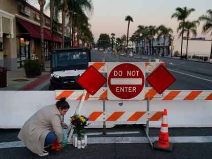 Stephanie Kozofsky, 31, leaves flowers and candles to honor the victims killed in Saturday's ballroom dance studio shooting in Monterey Park, Calif., Sunday, Jan. 22, 2023.